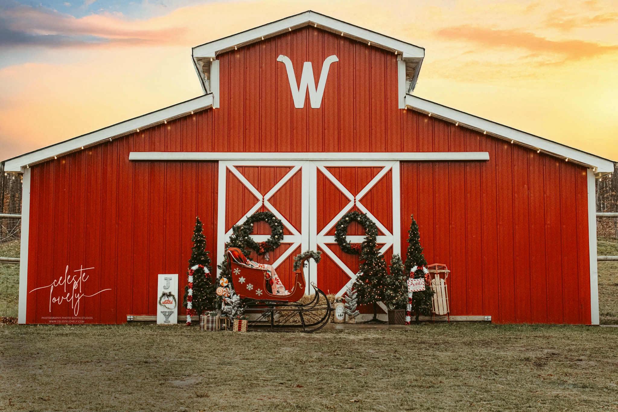 The red barn at Wilderness Valley Farm decorated for Christmas with a sleigh, wreaths and lit trees near Gaylord, Michigan