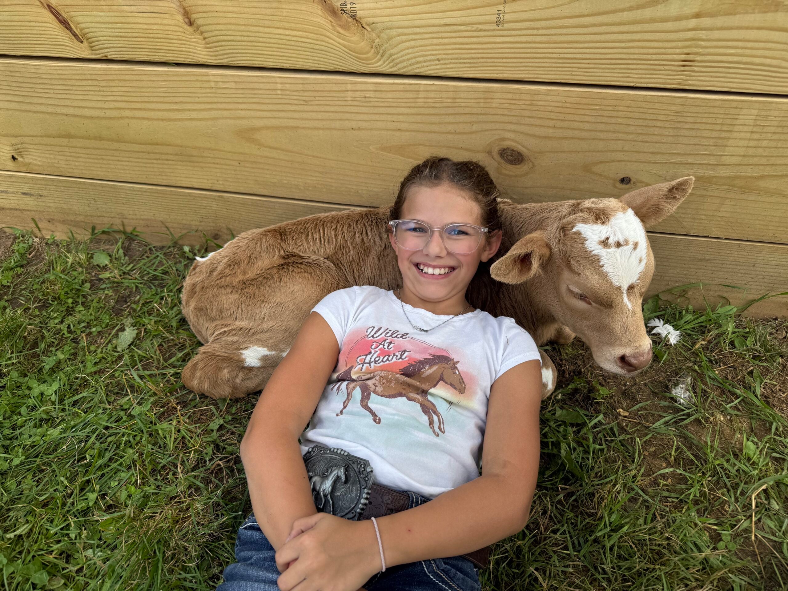 A student cuddling a bottle calf at Wilderness Valley Farm near Gaylord, Michigan